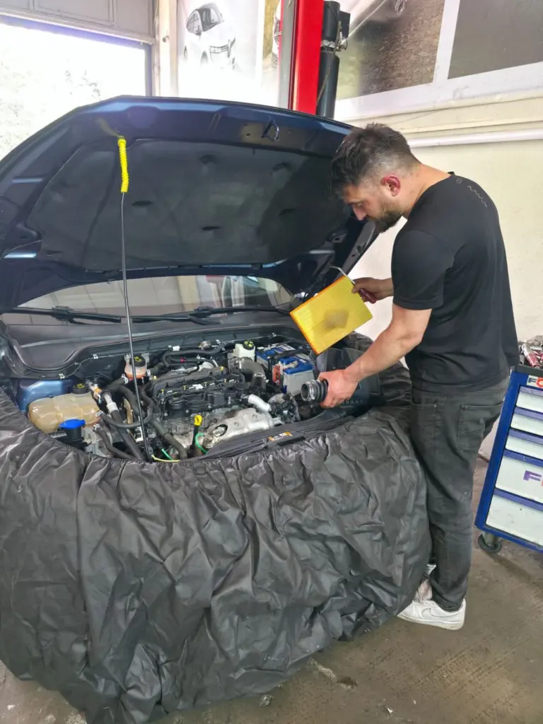 Usta, motordan çıkardığı hava filtresini inceliyor
